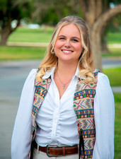Madison Dyment headshot in front of green backdrop
